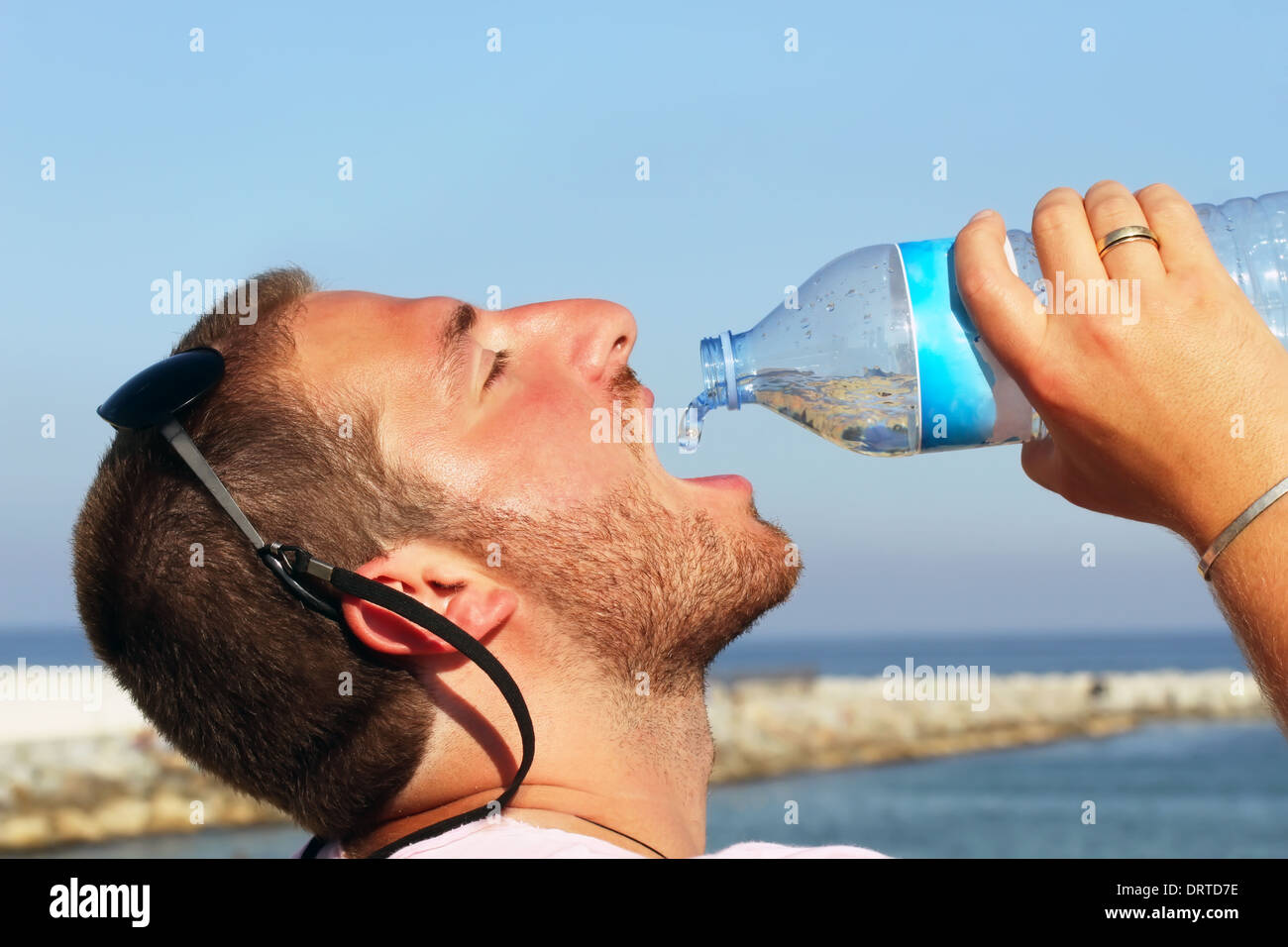 Un hombre sediento ávidamente de beber agua de botella de plástico  Fotografía de stock - Alamy