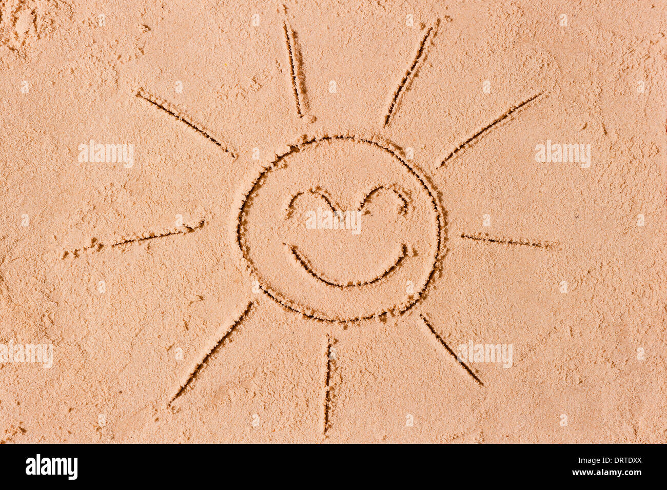 Figura alegre el sol en la arena Foto de stock