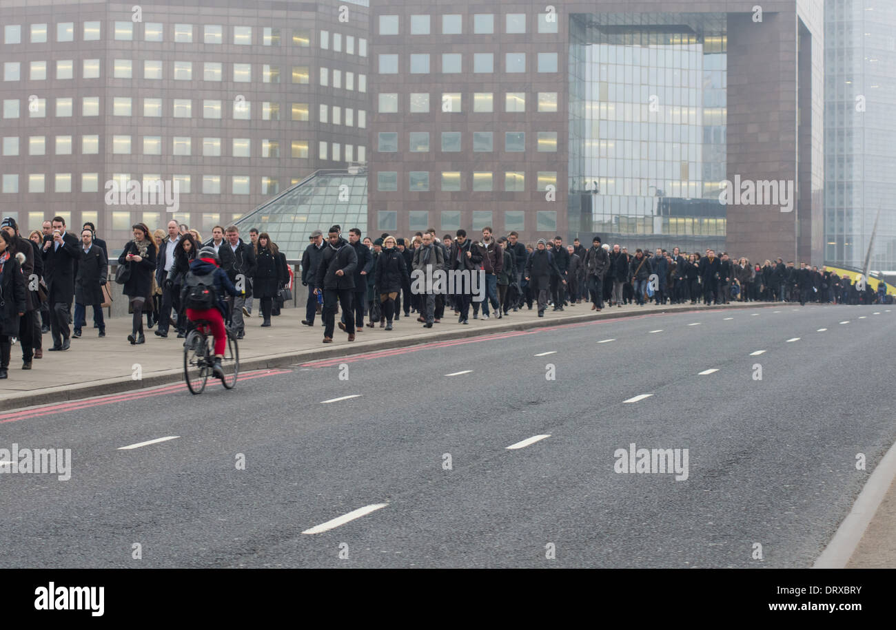 Los trabajadores de oficina a pie cruzando el Puente de Londres en su camino a la ciudad de Londres, Inglaterra, Reino Unido Foto de stock