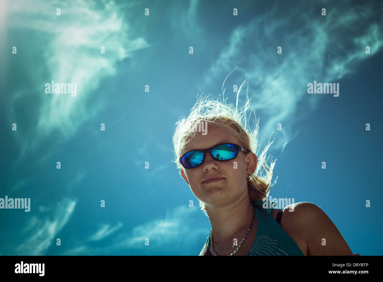 Mujer sonriente vistiendo sport gafas de sol más brillante Foto de mujer sonriente escalador con gafas de sol sentado