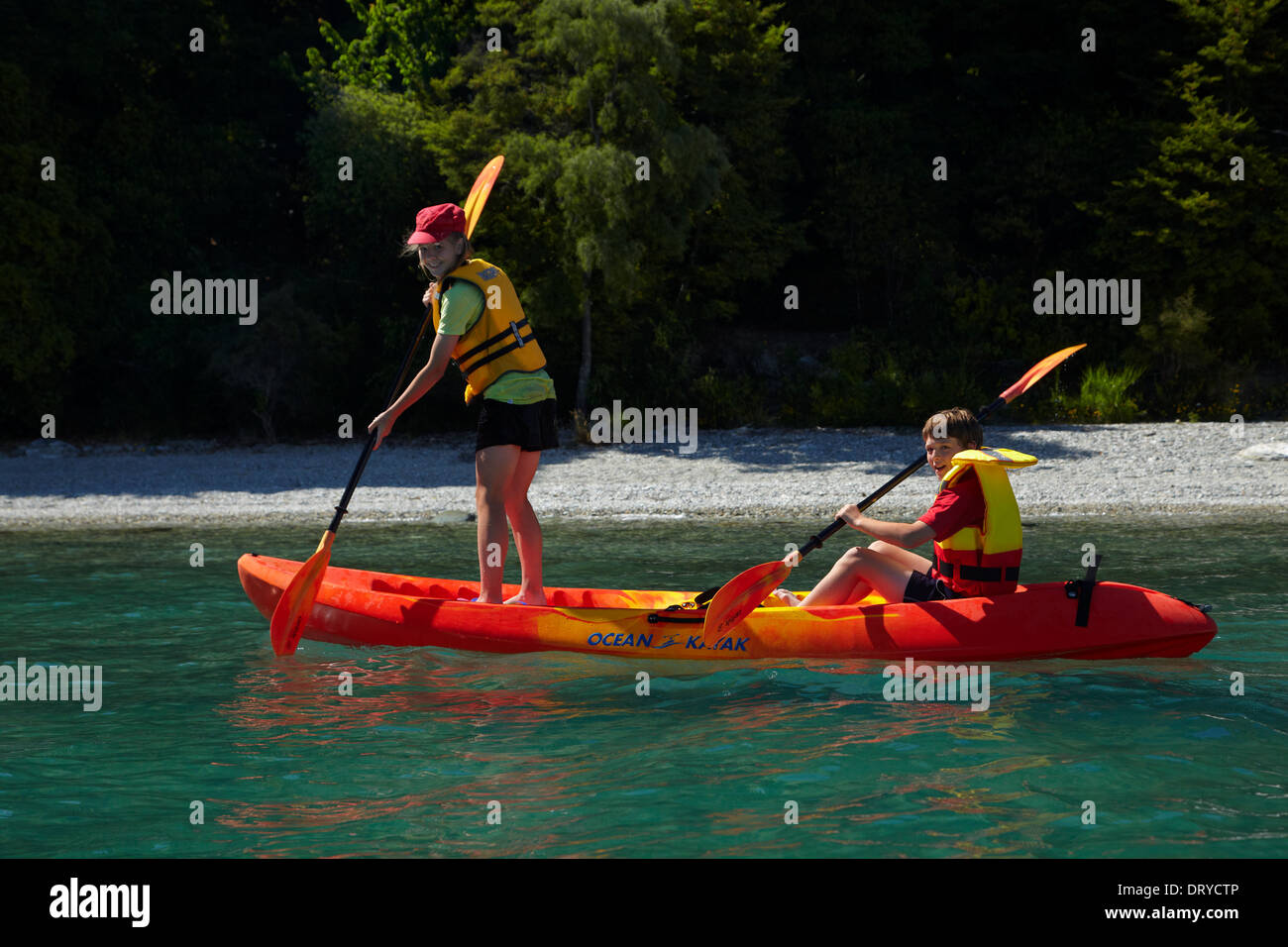 Niños jugando en kayak doble, Sunshine Bay, el lago Wakatipu, Queenstown, Otago, Isla del Sur, Nueva Zelanda Foto de stock