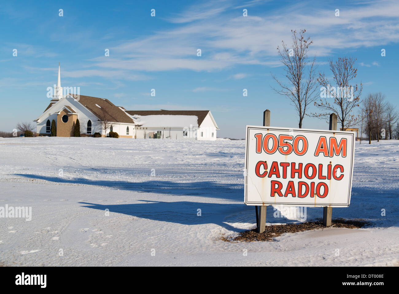 Cartel de publicidad de radio católica en frente de la iglesia local