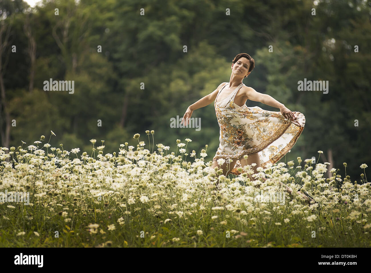 Nueva York, EE.UU. Woodstock mujer bailando en el campo de flores silvestres Foto de stock