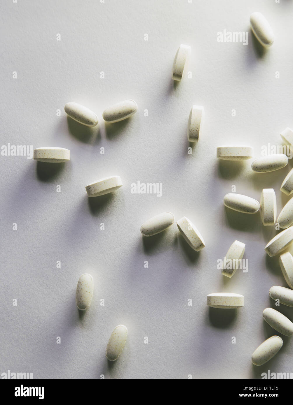 Los suplementos de vitamina C. tabletas oval blanco extendido sobre un fondo blanco. Foto de stock