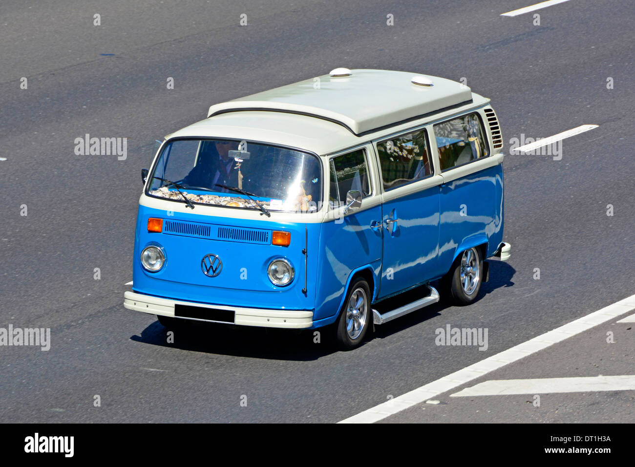 Azul y blanco icónico clásico VW Volkswagen camper van con bajada de techo elevable conduciendo por la autopista Inglaterra Fotografía stock -