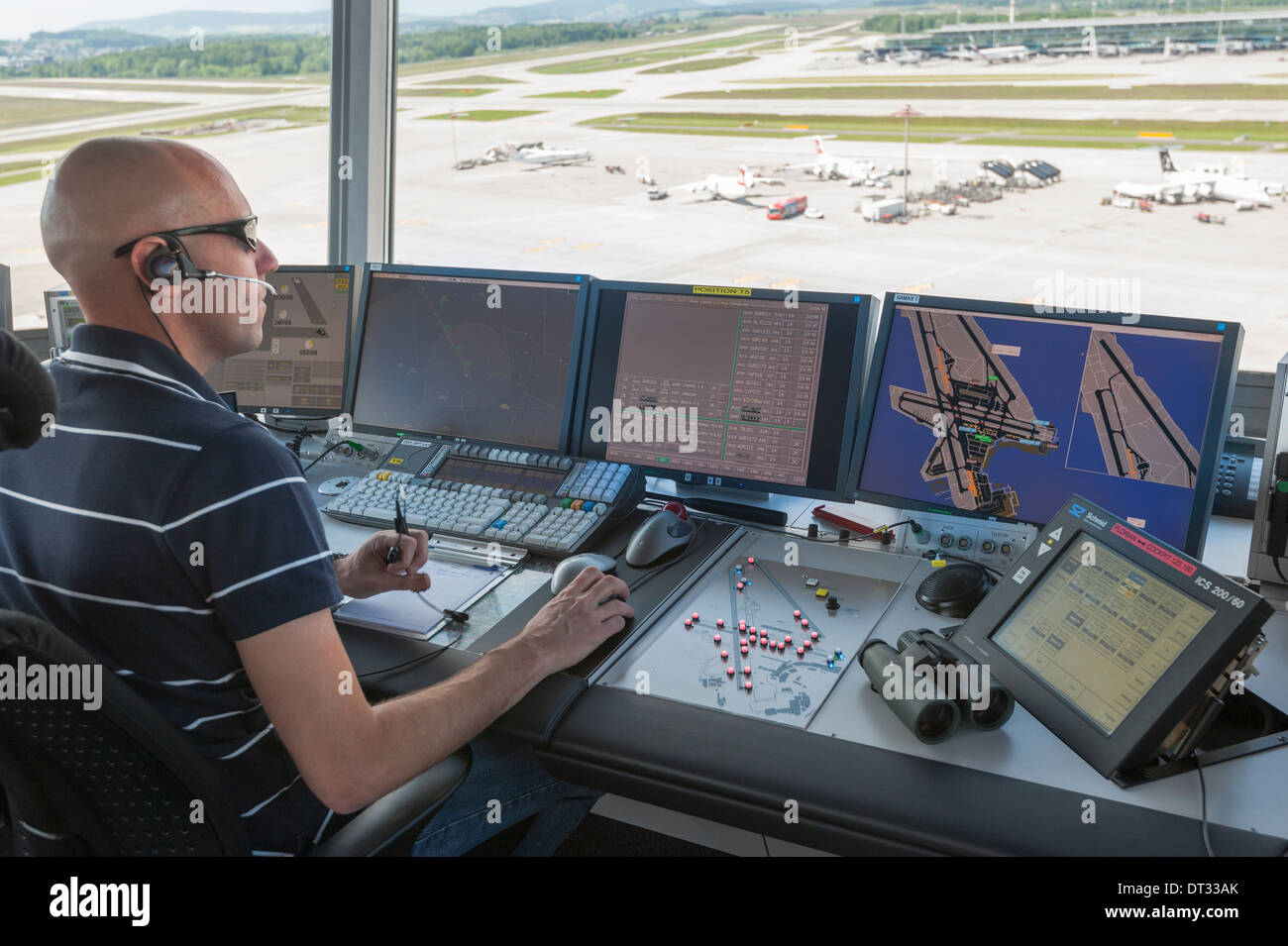 Un controlador de tráfico aéreo en la torre de control del aeropuerto internacional de Zúrich Kloten/está supervisando el aeródromo del aeropuerto. Foto de stock