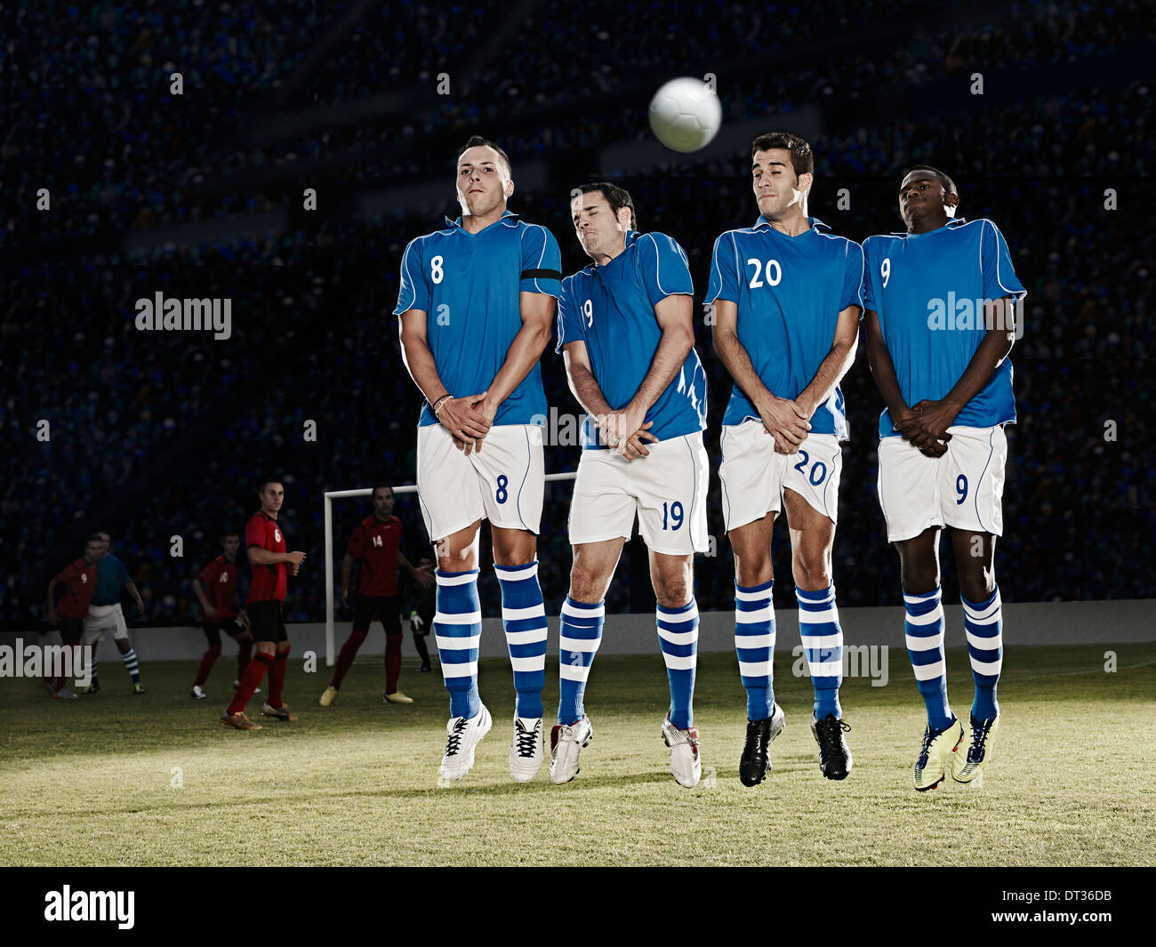 Jugadores de fútbol en el campo saltar Foto de stock