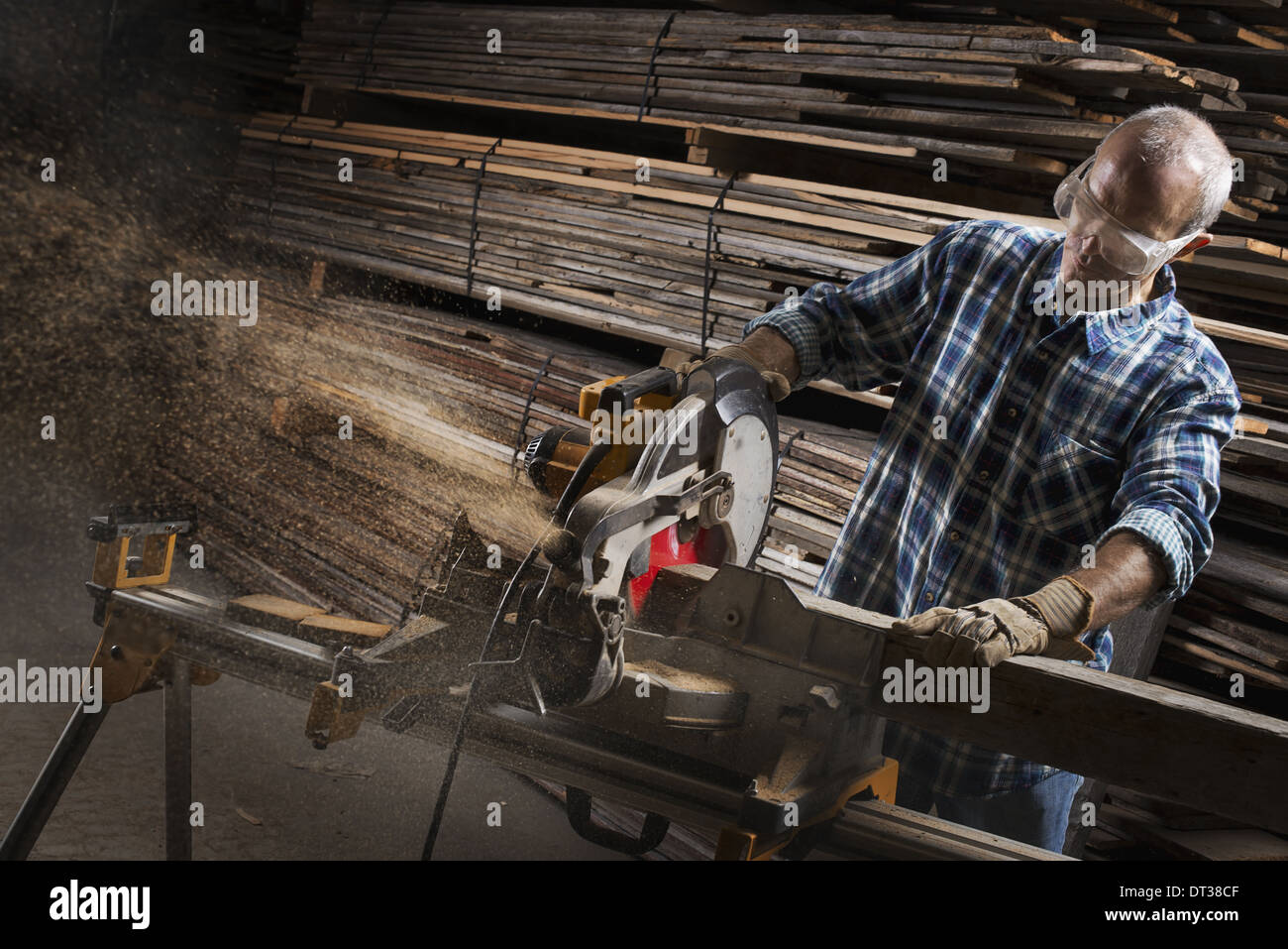 Un taller de madera recuperada. Un hombre en gafas de protección usando una  sierra circular para cortar madera Fotografía de stock - Alamy