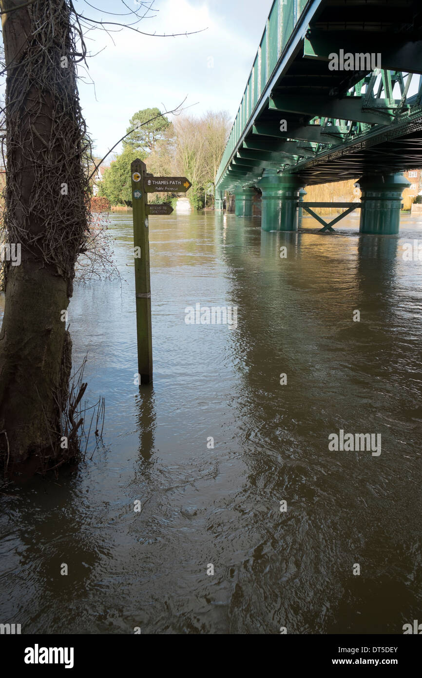 Inundada por el río Támesis por el puente peatonal en Bourne End Bucks UK Foto de stock