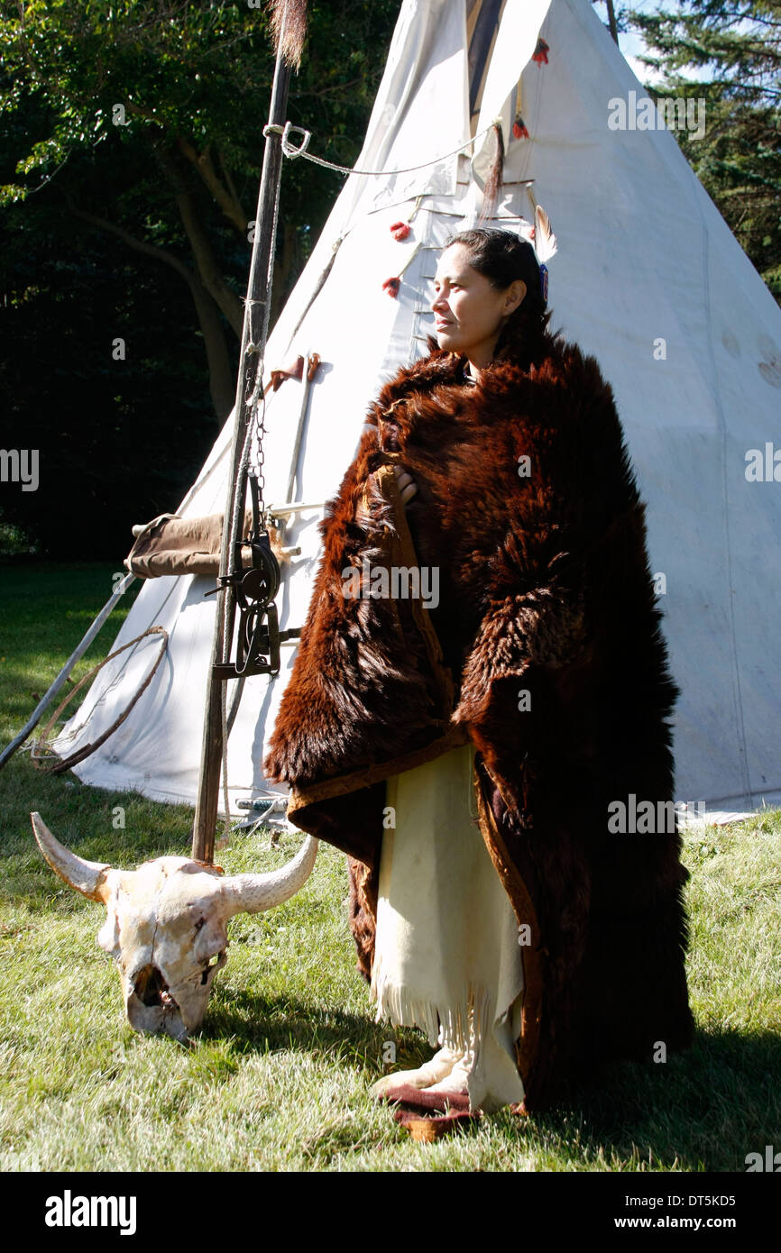 Un americano nativo Lakota Sioux mujer india en una túnica de búfalo por un  tipi Fotografía de stock - Alamy