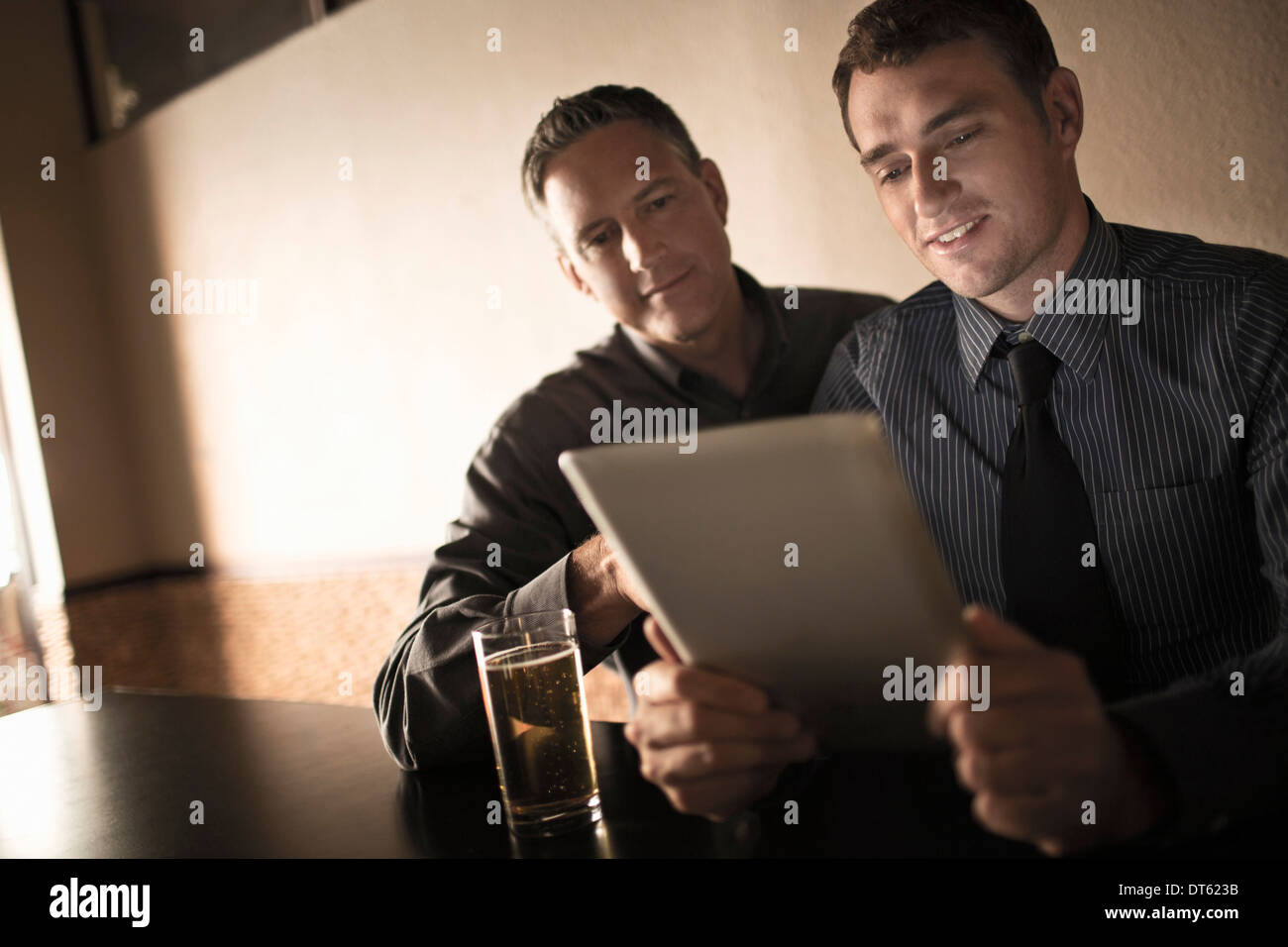 Dos compañeros de trabajo buscando en tableta digital en wine bar Foto de stock