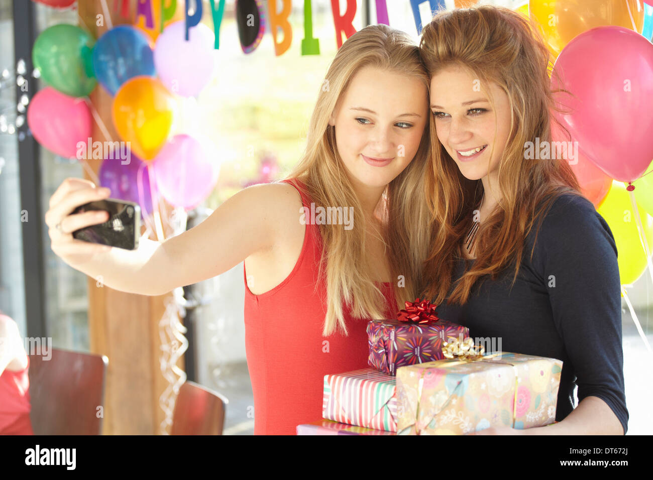 Dos chicas adolescentes teniendo selfie en fiesta de cumpleaños Foto de stock