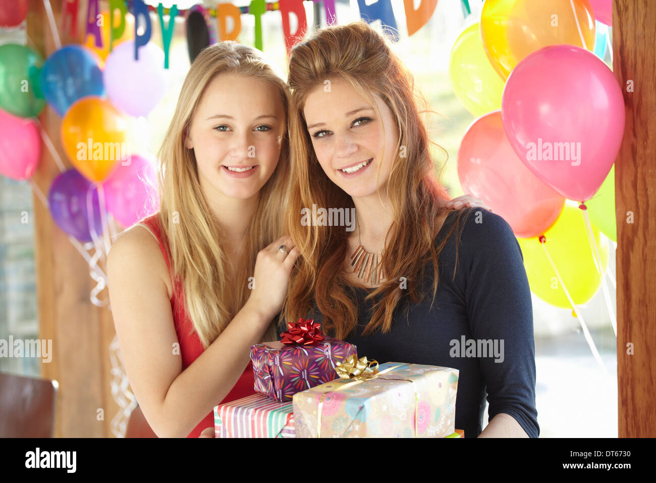 Dos chicas adolescentes compartiendo regalos en la fiesta de cumpleaños Foto de stock