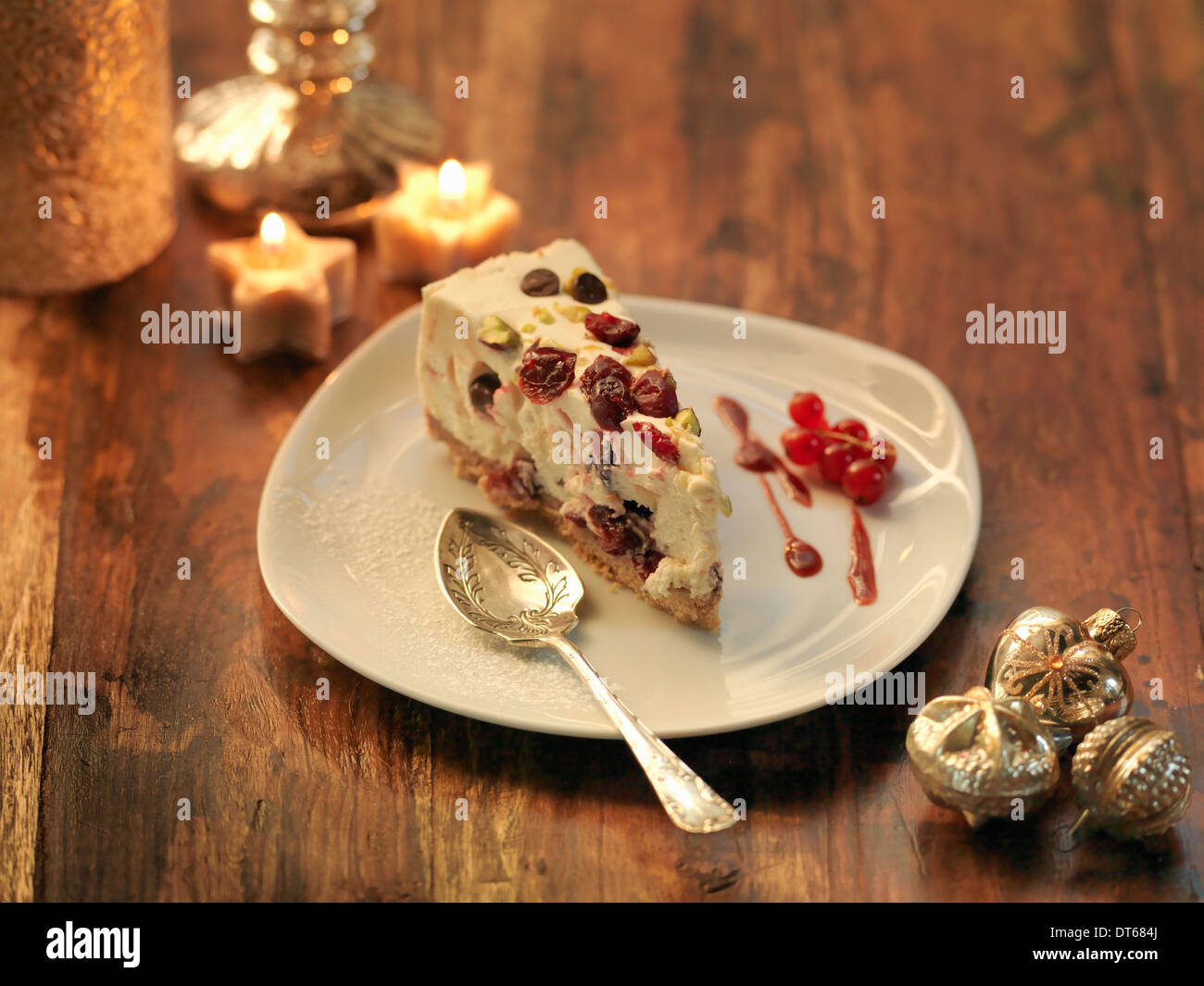 Tarta de queso mascarpone con arándanos, pistachos, la ralladura de naranja y chocolate chip entre decoraciones festivas Foto de stock