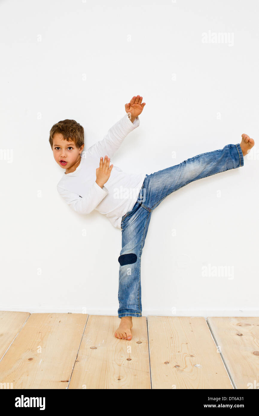 Foto de estudio de boy hacer karate kick Foto de stock