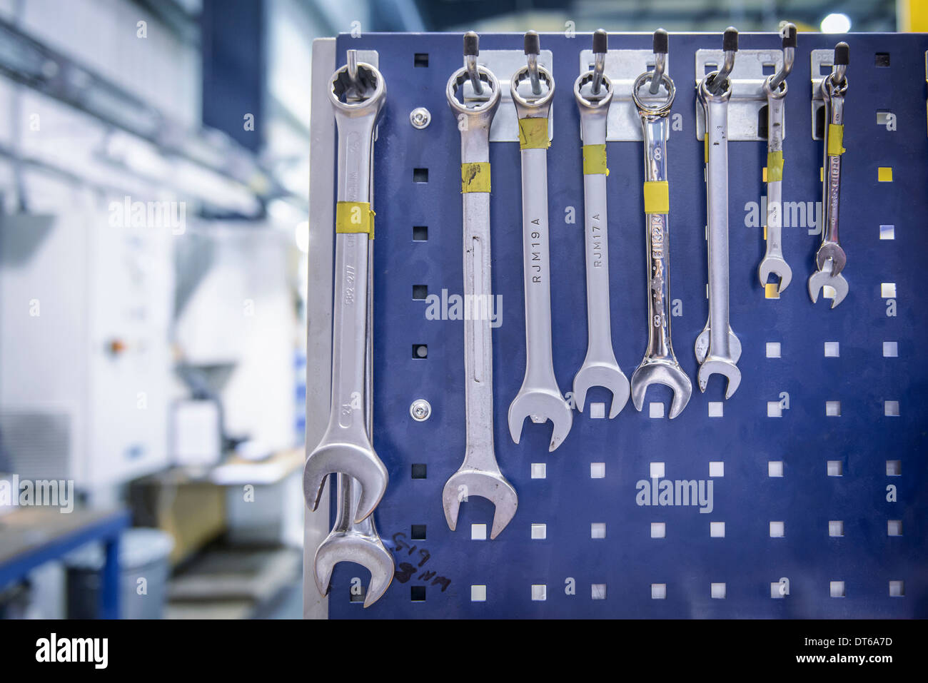 Variedad de llaves colgando del bastidor de estación de trabajo en la fábrica. Foto de stock