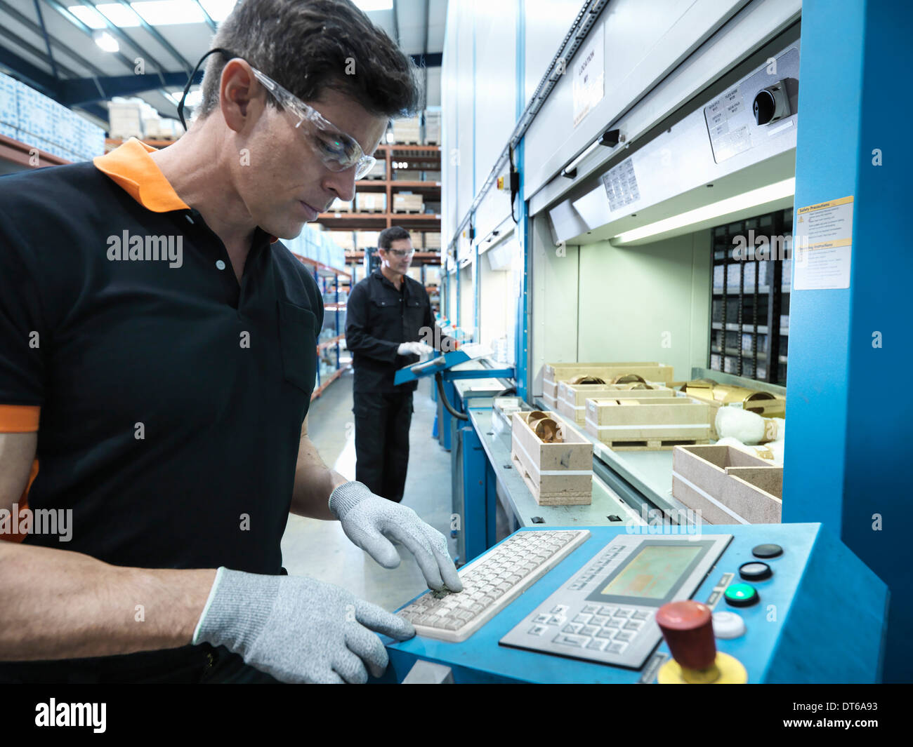 Ingenieros elegir piezas de almacén automatizado en la fábrica. Foto de stock