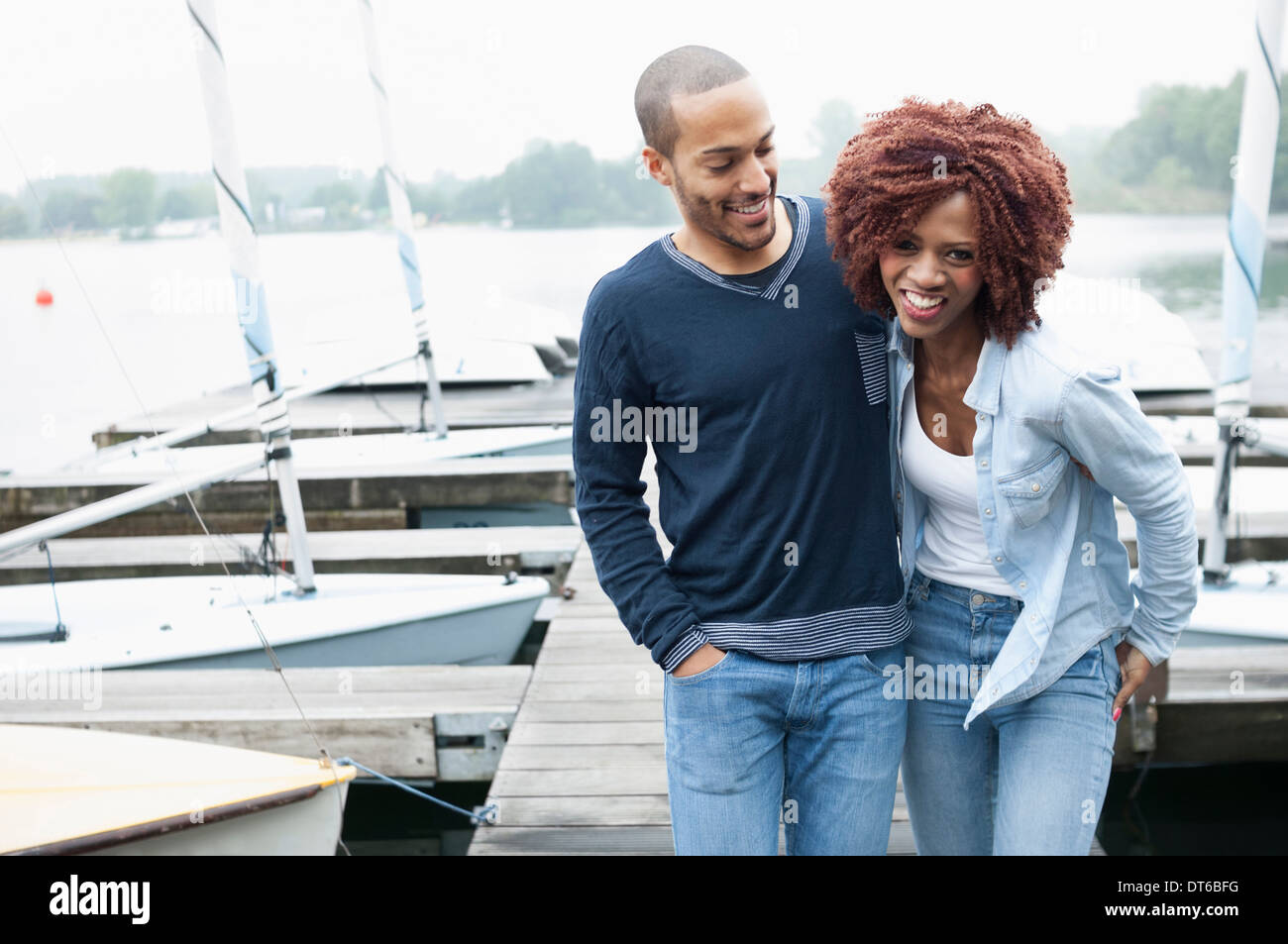 Pareja joven en jetty riendo Foto de stock