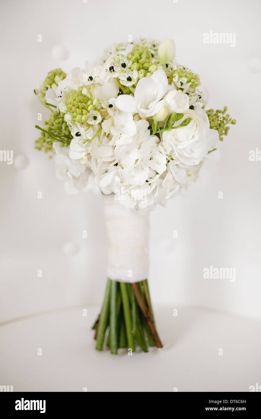 Una boda bouquet. Flores blancas, verdes cabezas de semillas y follaje.  Tallos verdes y la cinta blanca Fotografía de stock - Alamy