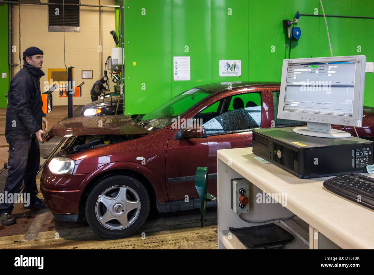 Inspector examinar el coche en el centro de pruebas MOT para un vehículo de motor de inspección anual Foto de stock
