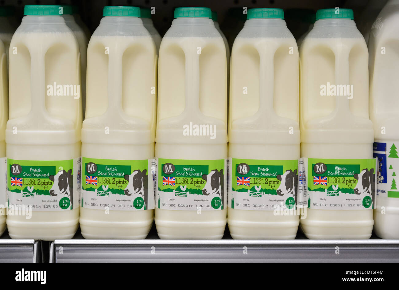 Botellas de leche expuestos para la venta en un supermercado británico Foto de stock