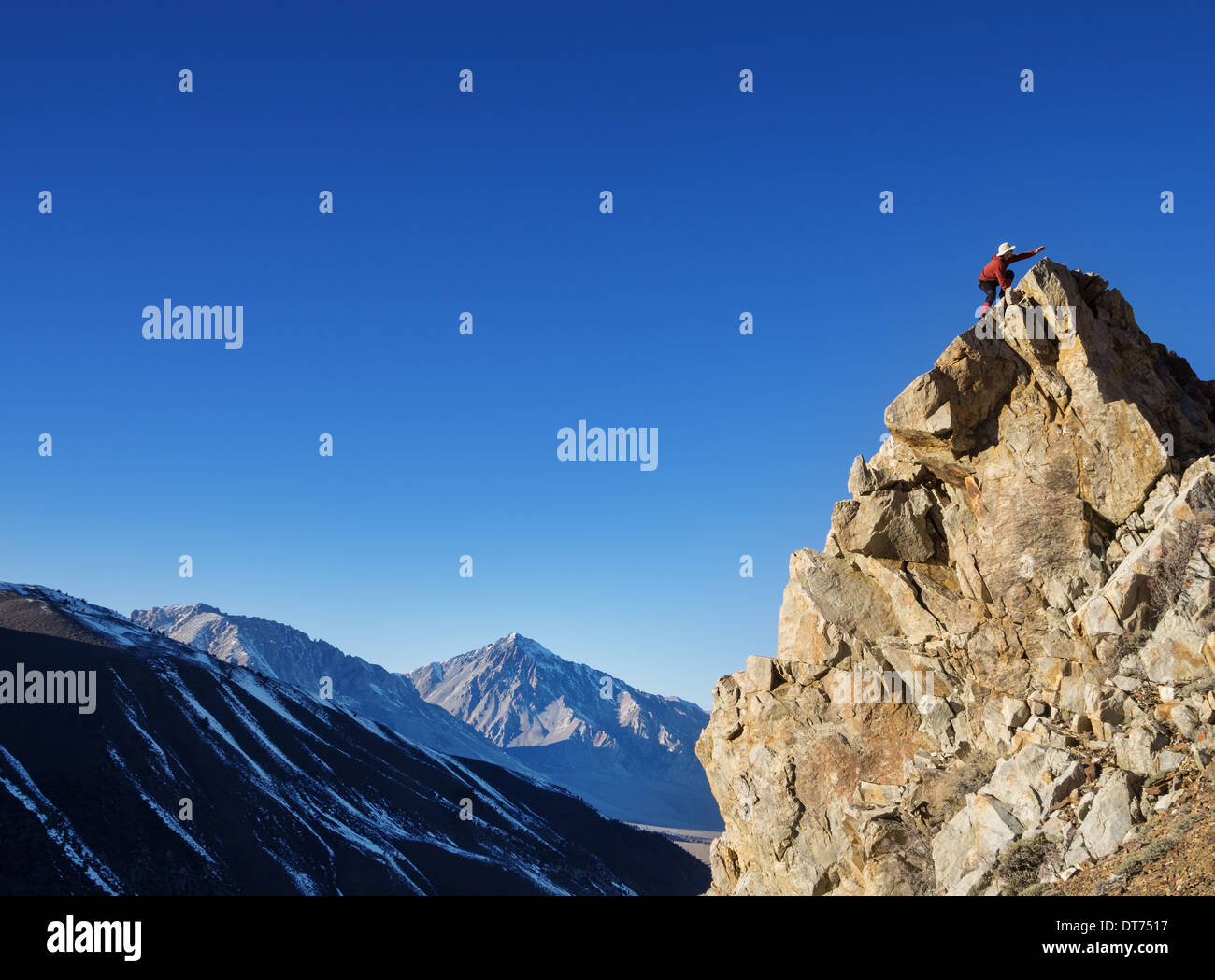Un hombre llega a su meta de la cima de la montaña Foto de stock