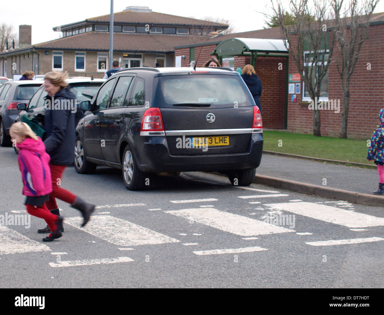 Los automóviles estacionados peligrosamente cerca de cebra fuera de una escuela. Foto de stock