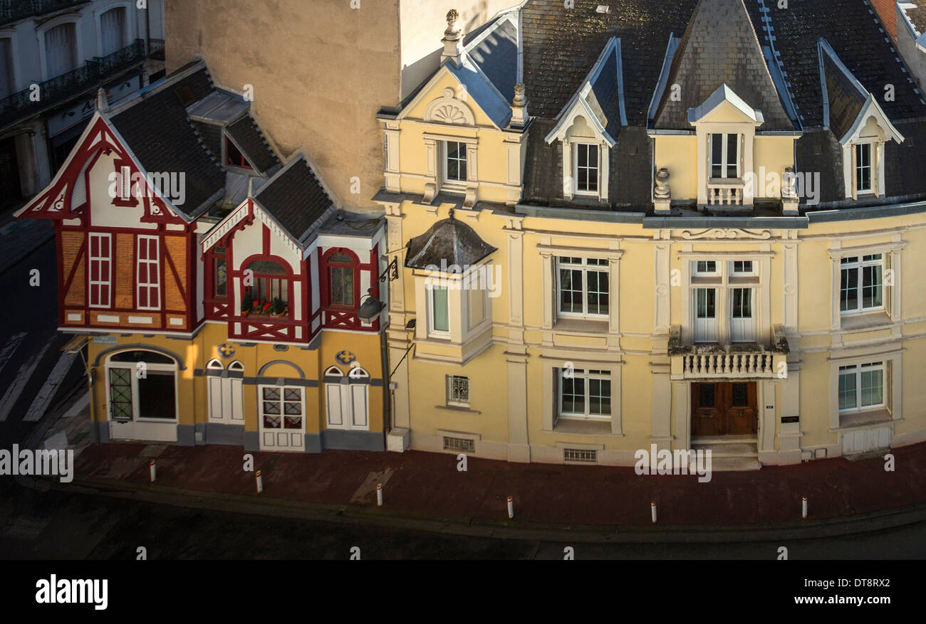 Vintage pequeño chalet construido en grandes bloques residenciales (Vichy, Francia). Edificio grande vs pequeña casa. Foto de stock