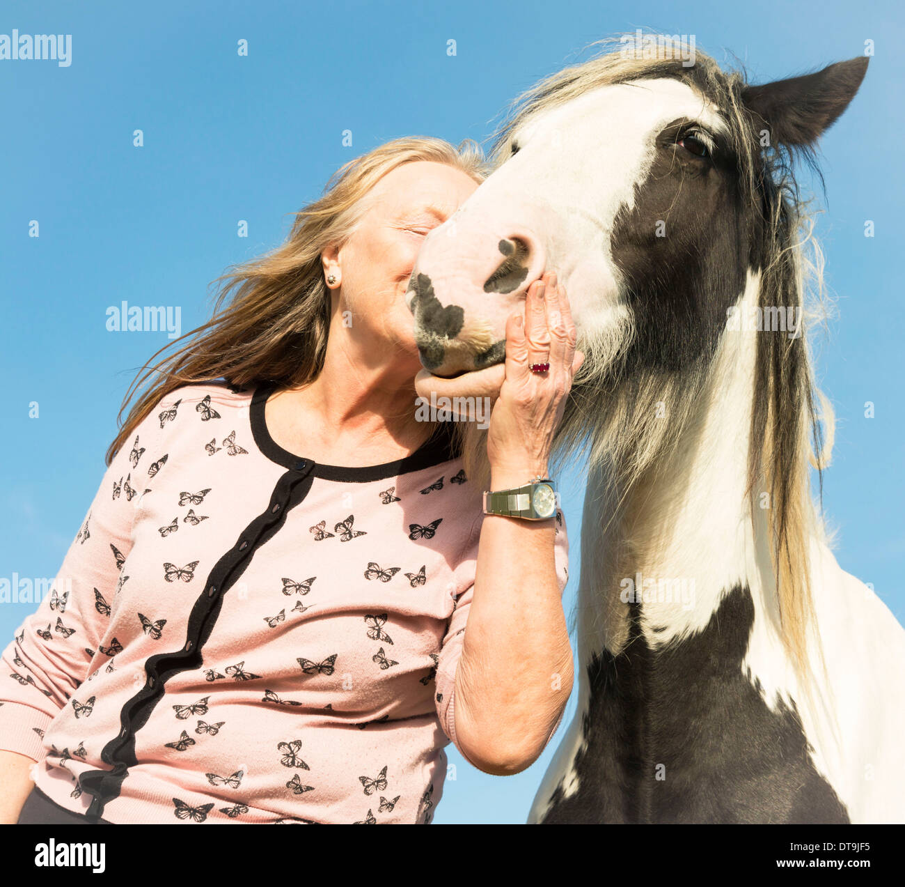 Mujer madura abrazando a caballo Foto de stock