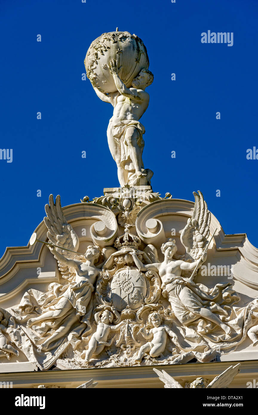 Estatua de Atlas sosteniendo la esfera celeste, ángeles y angelotes alrededor del escudo de armas de Baviera en el frontón de Schloss Foto de stock