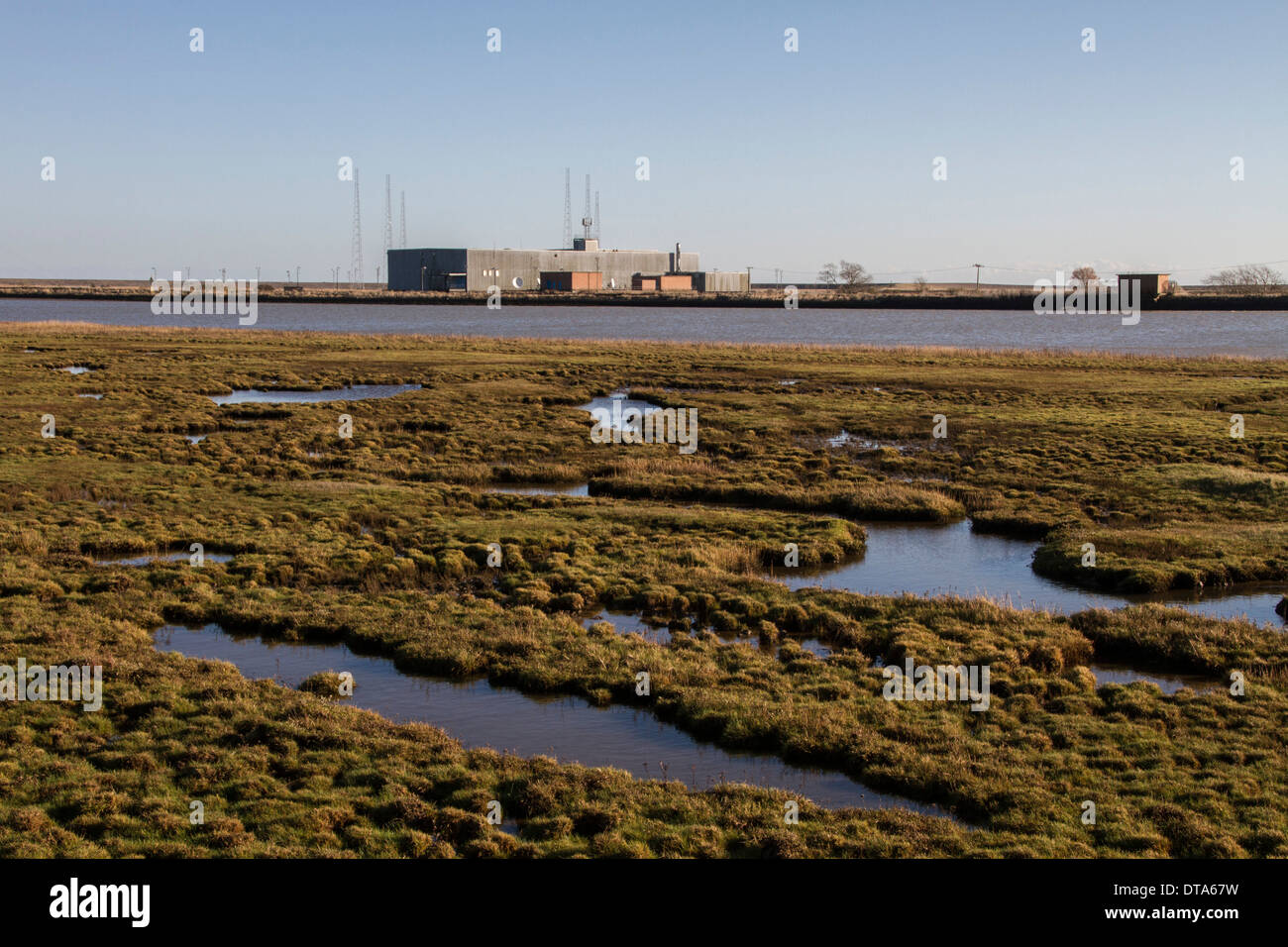 Mirando por encima de marismas en el borde del río Alde, East hacia la estación de radio y de los mástiles de Orford Ness, Suffolk. Foto de stock