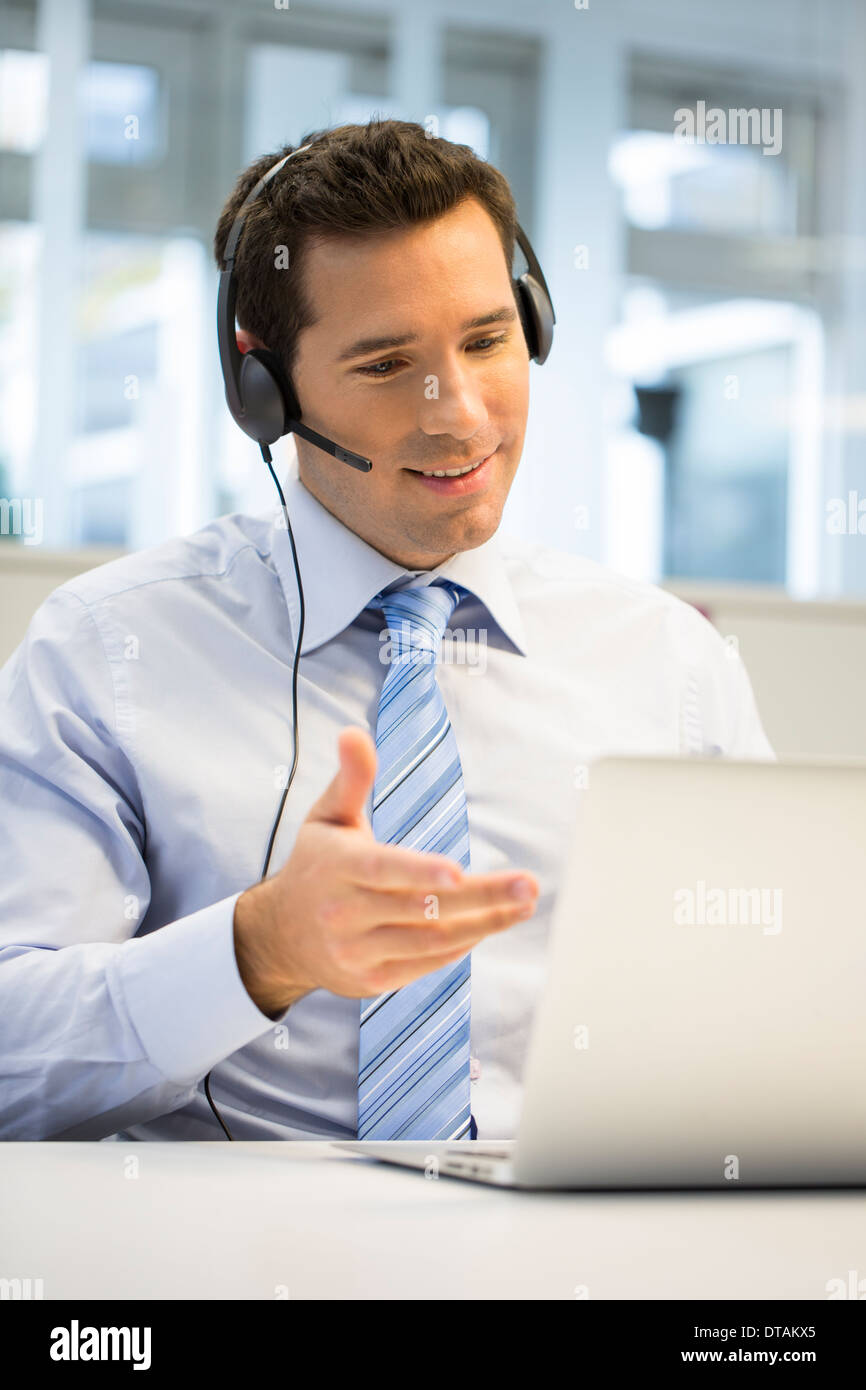 El empresario en la oficina por teléfono con auriculares, hotline Foto de stock