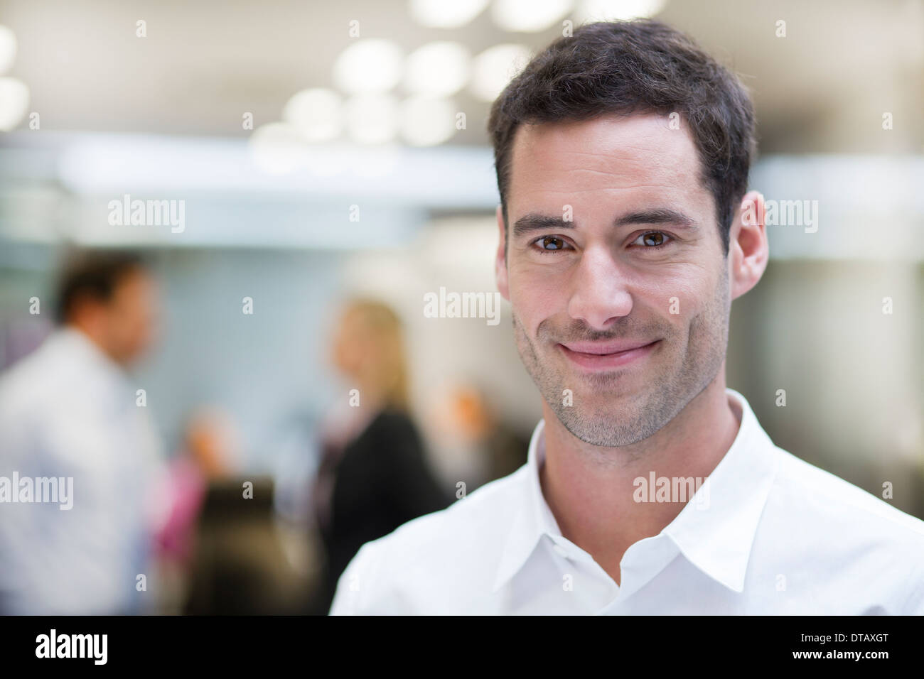 Retrato de sonriente empresario guapo en la oficina, mirando la cámara Foto de stock