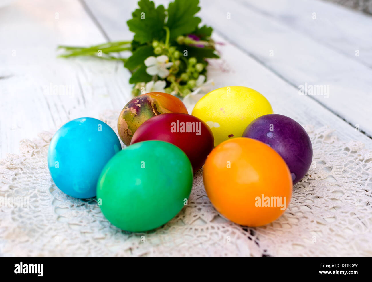 Coloridos huevos de Pascua decorados con geranios blancos Foto de stock