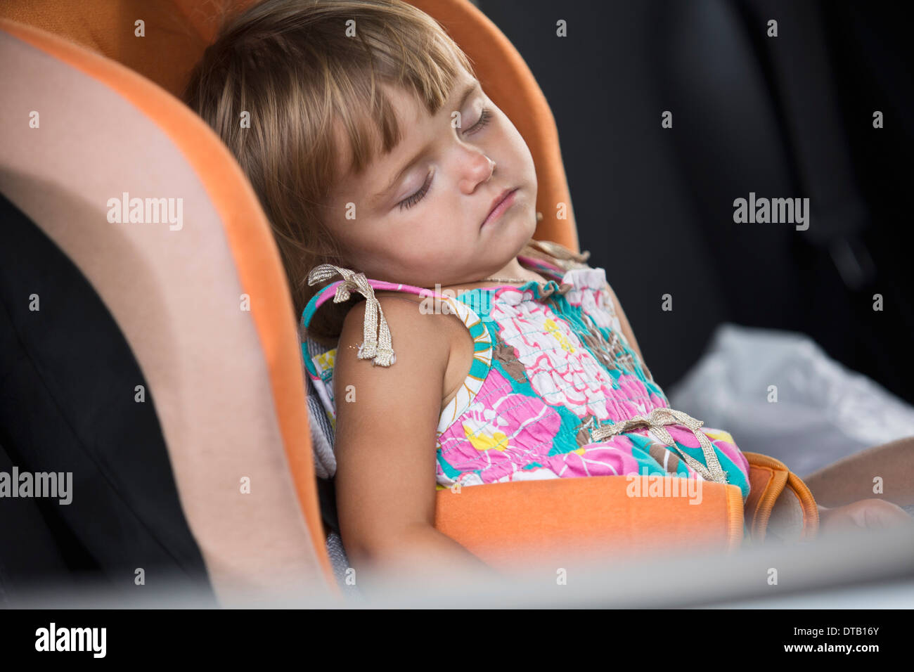 Baby Girl dormir sobre el asiento del vehículo. Foto de stock