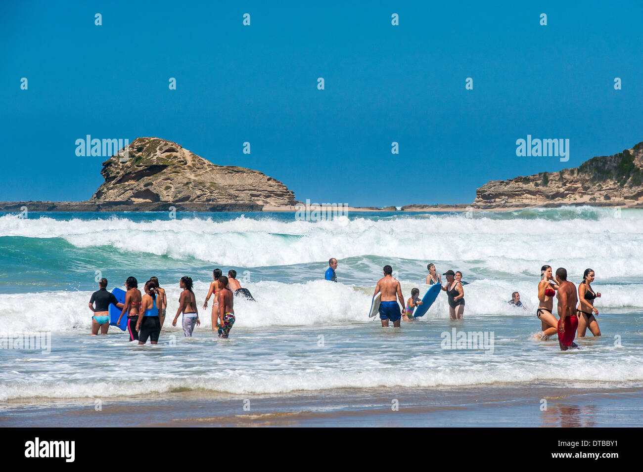 Los turistas disfrutar nadando en las olas de frenado en Sedgefield, Eastern Cape, Sudáfrica Foto de stock