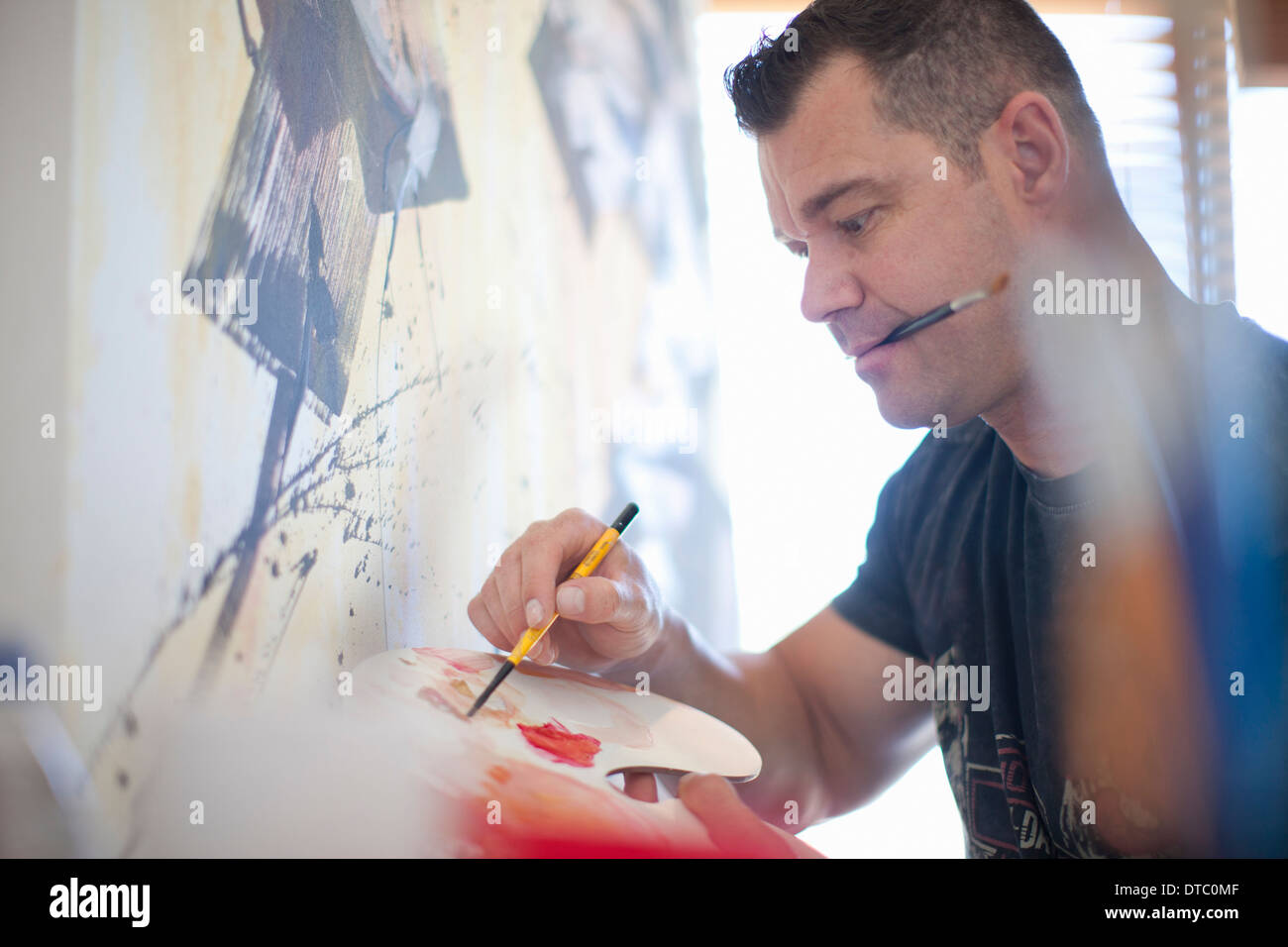 Macho maduro pintando lienzo en studio Foto de stock