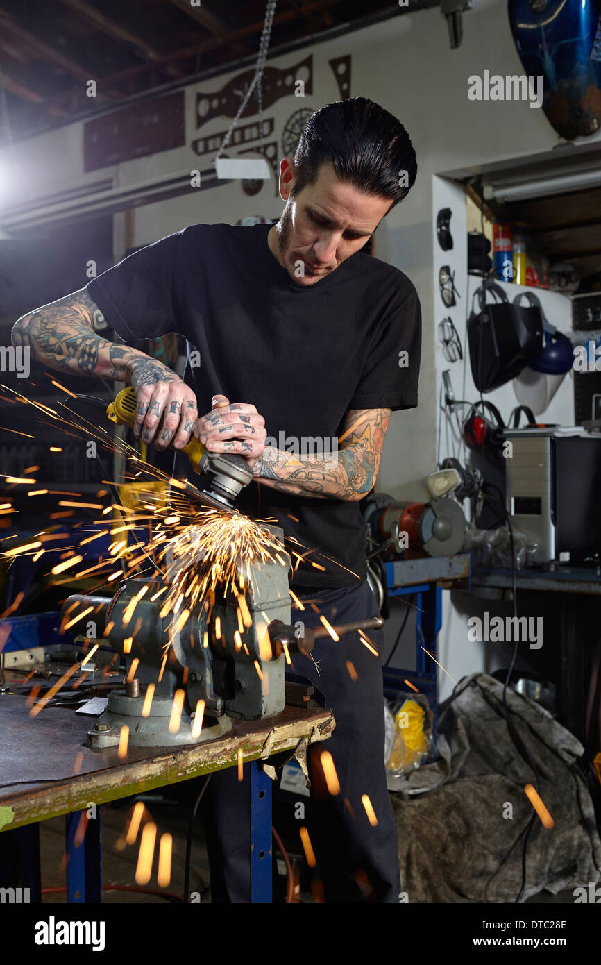 Hombre maduro soldar piezas en el taller de reparación de motocicletas Foto de stock