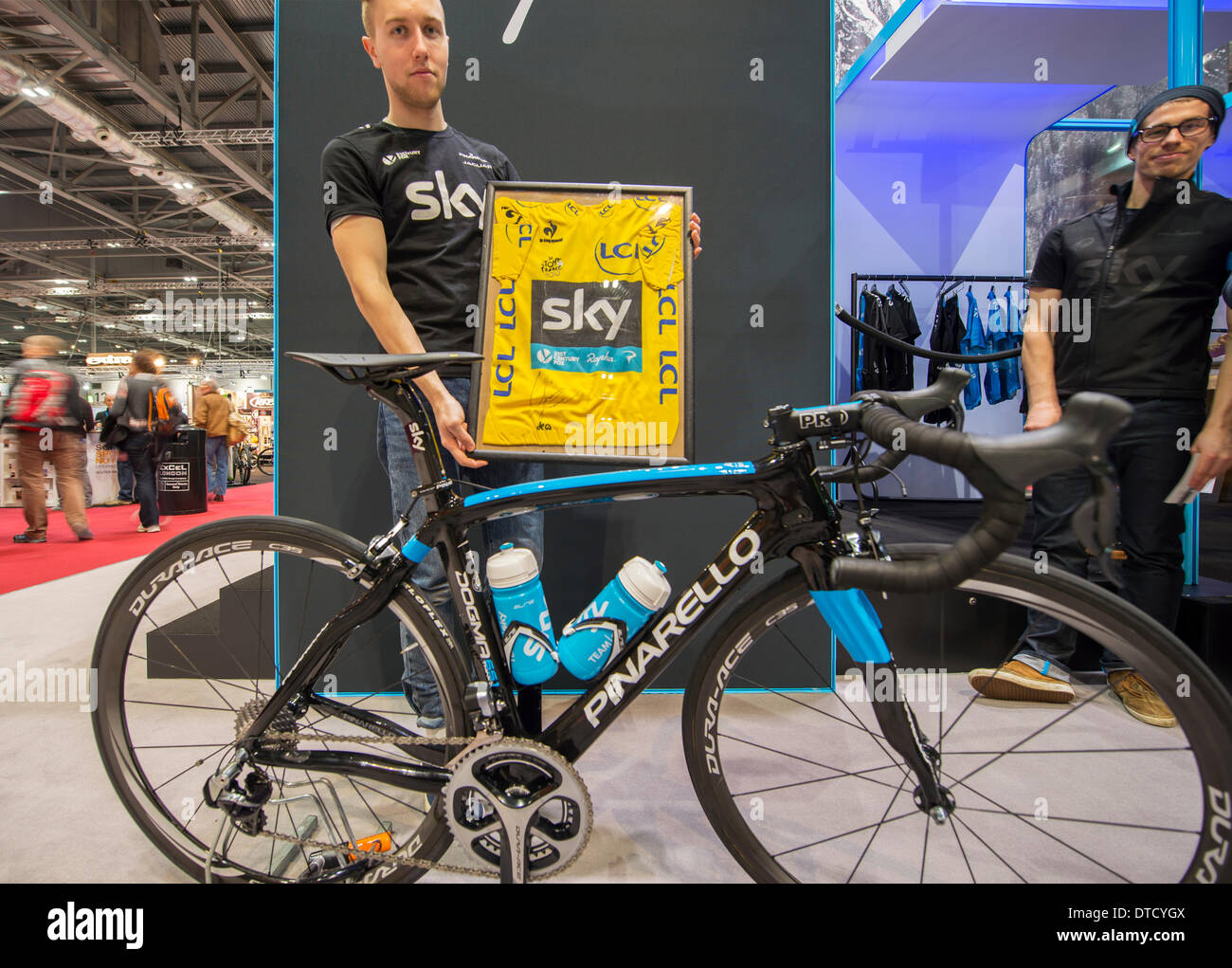 Londres, Reino Unido. 15 Feb, 2014. La más grande del Reino Unido  exhibiciones de ciclismo muchas nuevas bicicletas. Un miembro del Sky Team  stand muestra el jersey amarillo del Tour de Francia