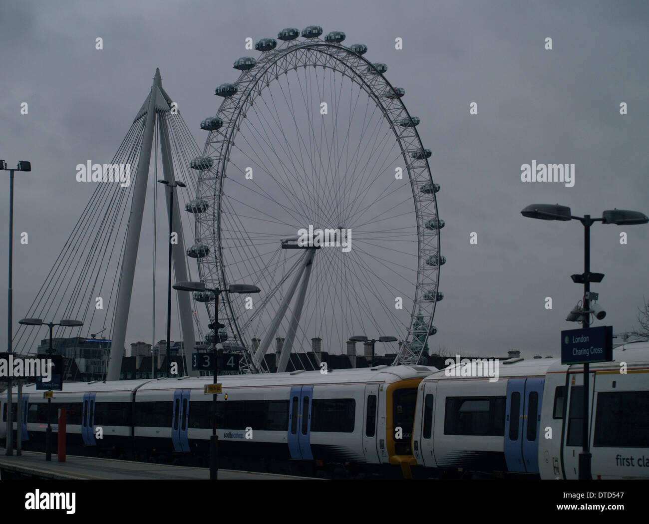 El London Millennium Wheel y tomadas desde un tren de Charing Cross Platform en una tarde de invierno mojado Foto de stock