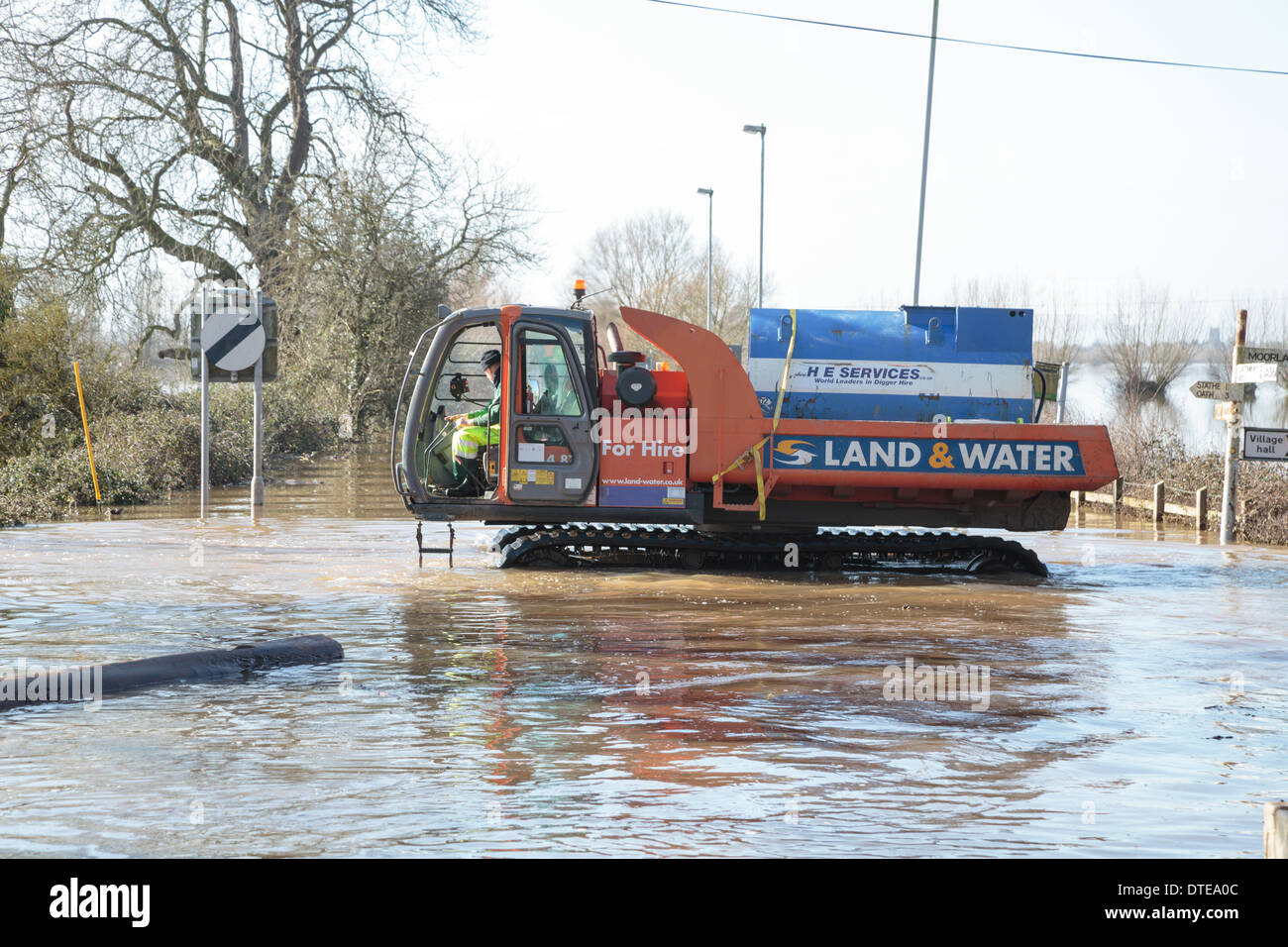 Burrowbridge, Reino Unido. 16 Feb, 2014. Los trabajadores hacen uso de vehículos especializados durante las fuertes inundaciones en los niveles Burrowbridge en Somerset, el 16 de febrero de 2014. Vehículos aptos para el uso en aguas profundas están siendo usados para eliminar obstáculos tales como los troncos de los árboles y postes de telégrafo con el agua para que la ayuda pueda ser distribuido a los residentes locales. El A361 es una importante vía arterial a través de los niveles de Somerset y acaba sufrió la peor inundación en su historia y ha sido ahora submarina durante siete semanas. Crédito: Nick Cable/Alamy Live News Foto de stock