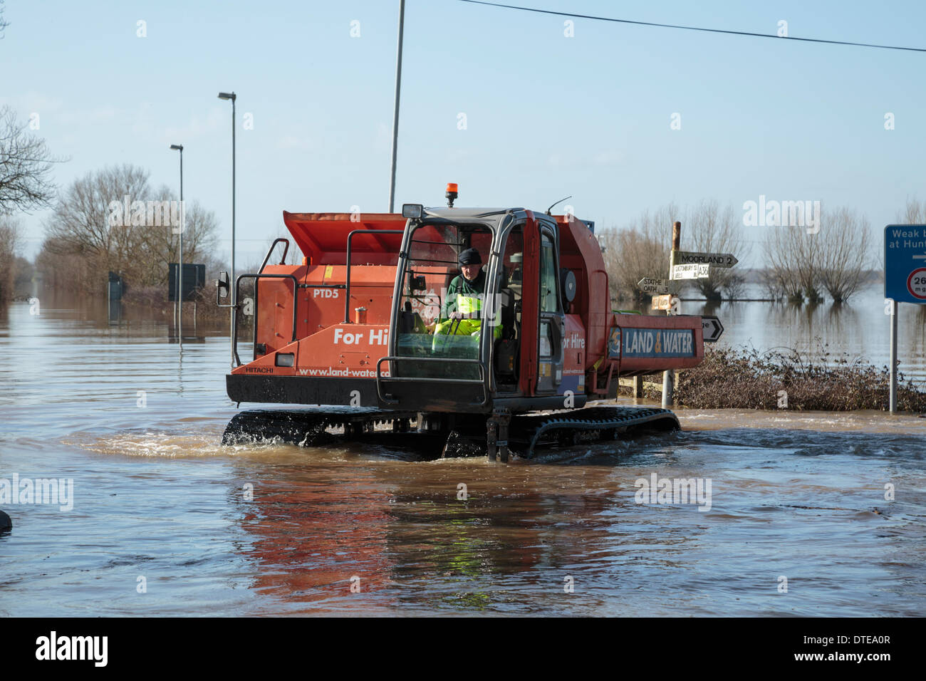 Burrowbridge, Reino Unido. 16 Feb, 2014. Los trabajadores hacen uso de vehículos especializados durante las fuertes inundaciones en los niveles Burrowbridge en Somerset, el 16 de febrero de 2014. Vehículos aptos para el uso en aguas profundas están siendo usados para eliminar obstáculos tales como los troncos de los árboles y postes de telégrafo con el agua para que la ayuda pueda ser distribuido a los residentes locales. El A361 es una importante vía arterial a través de los niveles de Somerset y acaba sufrió la peor inundación en su historia y ha sido ahora submarina durante siete semanas. Crédito: Nick Cable/Alamy Live News Foto de stock