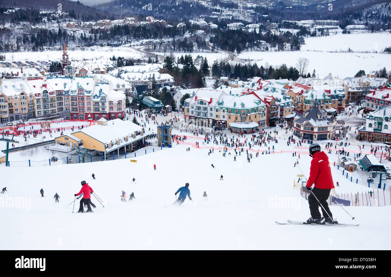 Mont-Tremblant, Canadá - 9 de febrero de 2014: los esquiadores y snowboarders están bajando la pendiente principal en Mont-Tremblant. Foto de stock