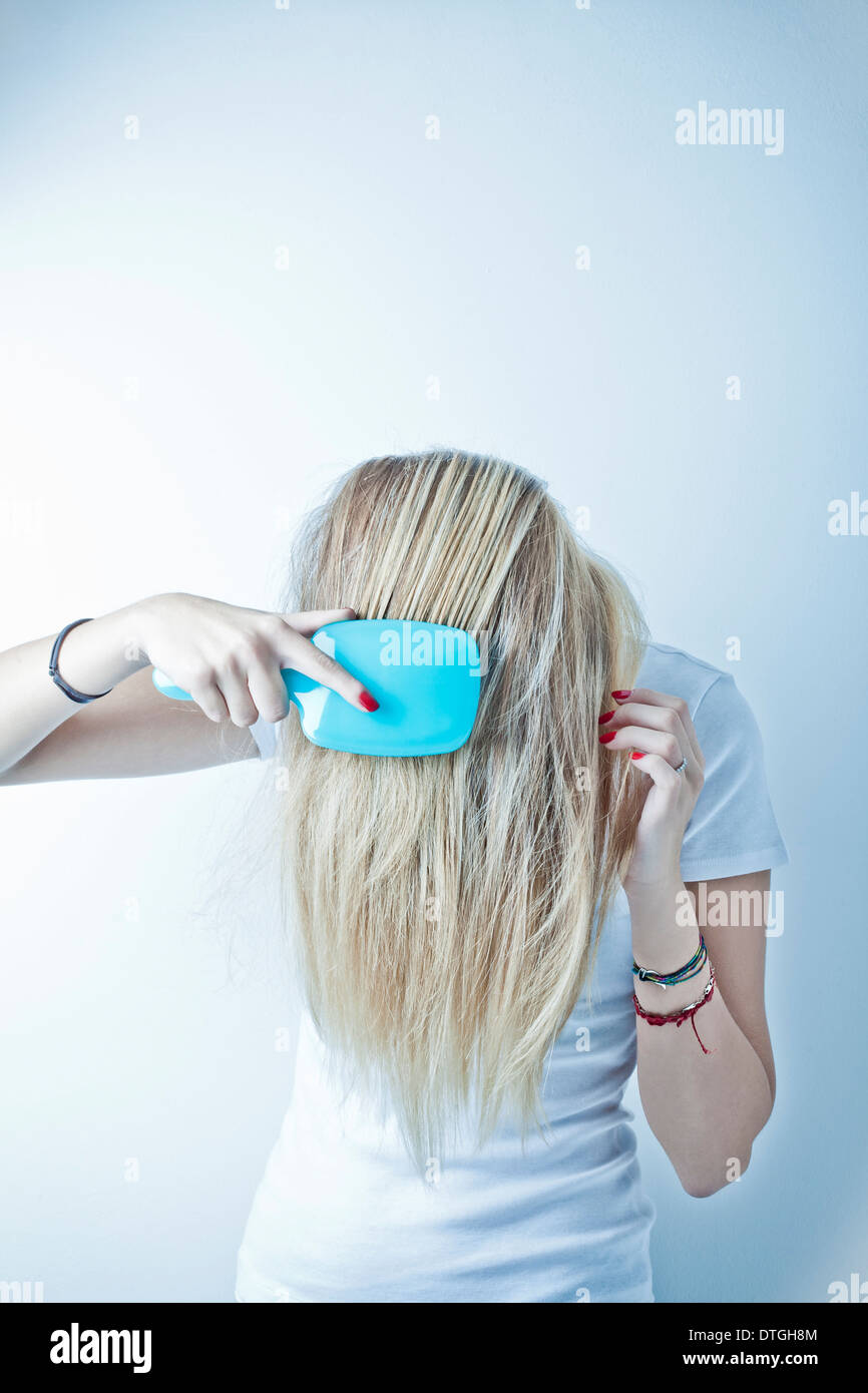 Adolescente cepilla el cabello Foto de stock