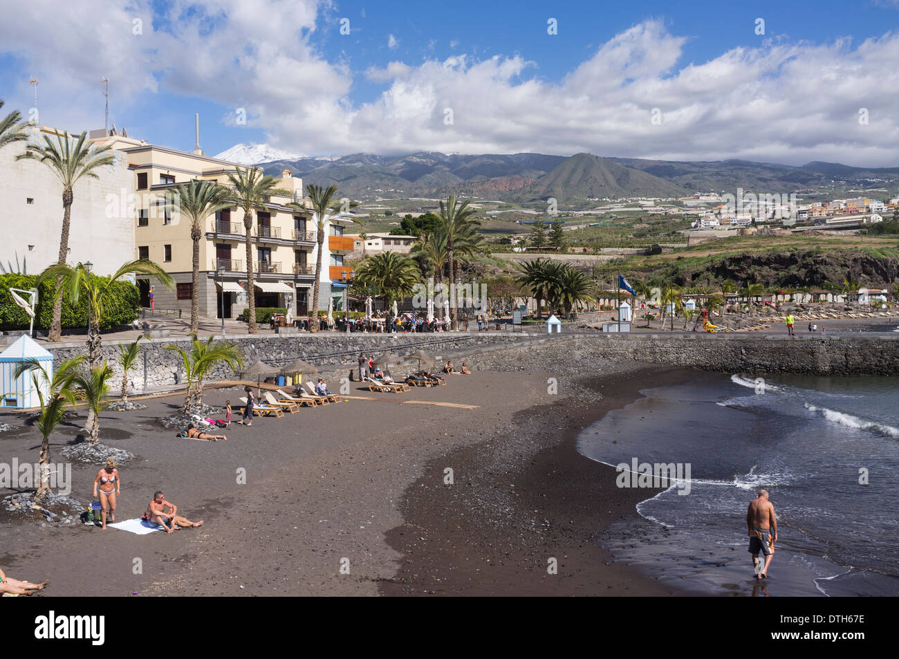 En la pequeña playa en Playa San Juan con nieve en las montañas detrás del Teide, Tenerife, Islas Canarias, España Foto de stock