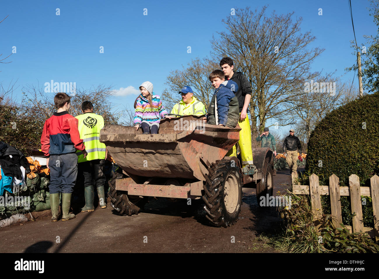 Los trabajadores de ayuda de voluntarios ayudan a distribuir suministros en la villa inundada de páramos en los niveles de Somerset. Foto de stock