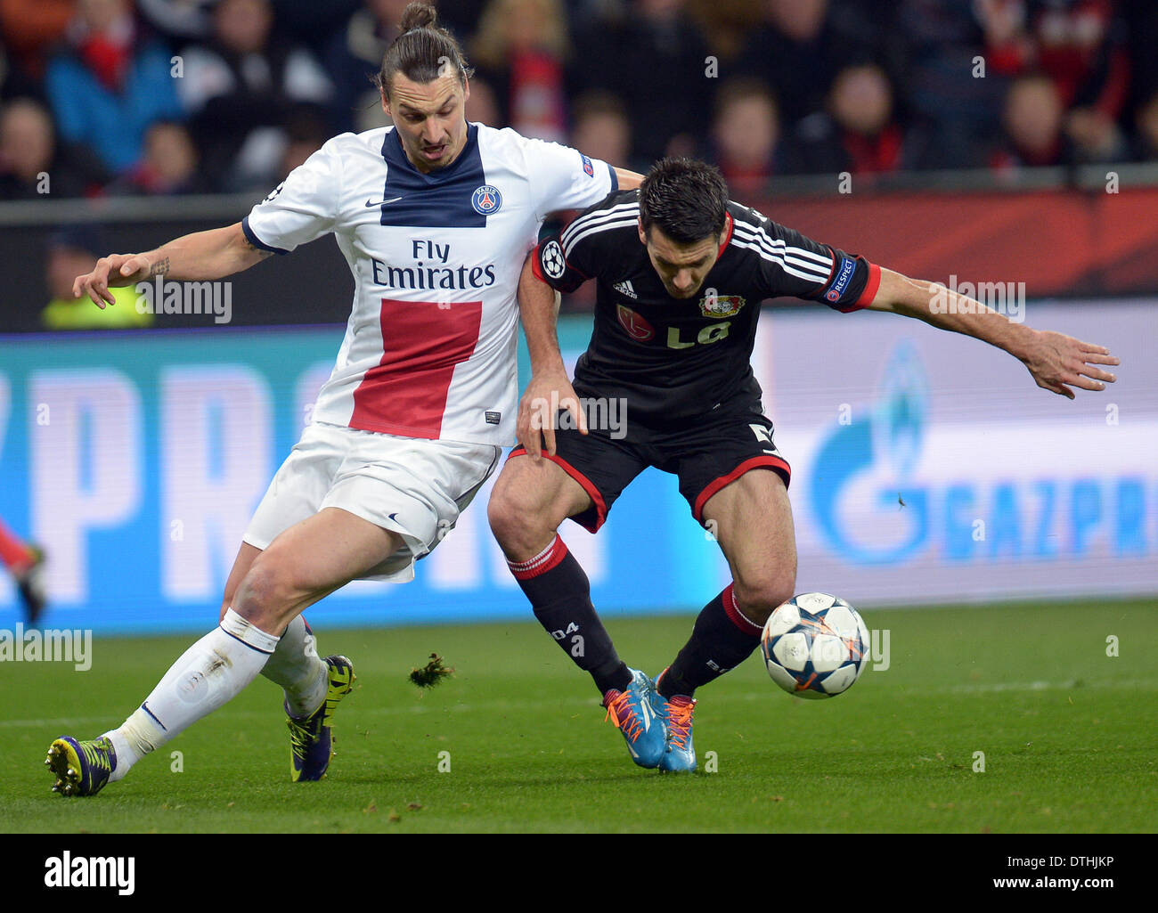 Leverkusen, Alemania. 18 de febrero de 2014. Zlatan Ibrahimovic de París  Saint Germain y Leverkusen jugador Emir Spahic han (camiseta negra), lucha  por el balón durante los octavos de final de la