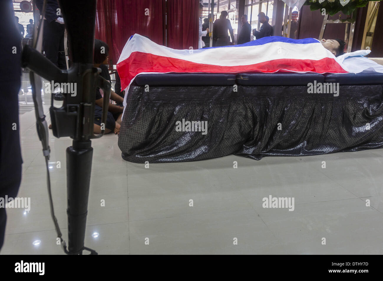 Bangkok, Tailandia. 19 Feb, 2014. Una guardia de honor en los rituales de baño, el primer paso en el ritual funerario budista, por Pol Sgt-Major Phianchai Pharawat Senior, 45. Phianchai fue asesinado por un grupo de manifestantes contra el gobierno el martes durante un altercado entre los manifestantes y la policía. Cuatro personas resultaron muertas y más de 60 hospitalizados como consecuencia de los combates. Crédito: Zuma Press, Inc./Alamy Live News Foto de stock