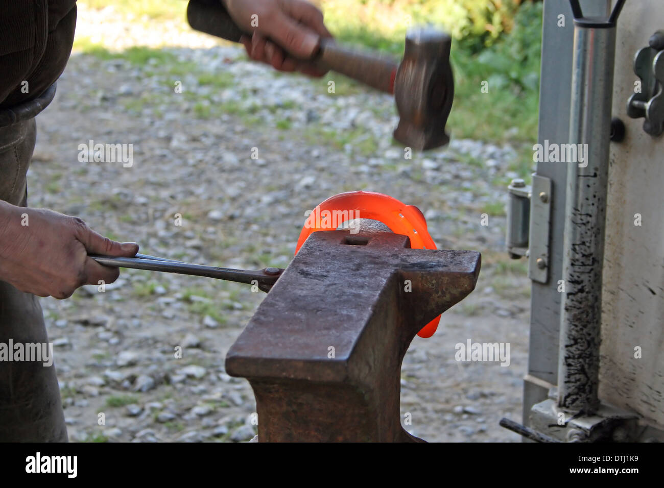 Herrero forja un hierro candente en la forja Fotografía de stock - Alamy
