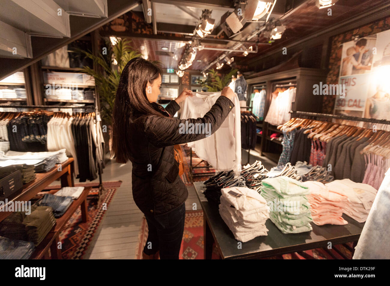 Una joven mujer de compras y comprar ropa en la tienda de moda Hollister,  Grand Arcade, Cambridge, Reino Unido Fotografía de stock - Alamy
